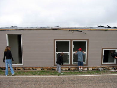 An overturned manufactued home on the side of the freeway